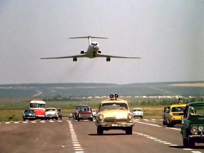 Ту-134 садится на аэродромную полосу, загримированную под шоссе.  Кадр из фильма "Невероятные приключения итальянцев в России" 